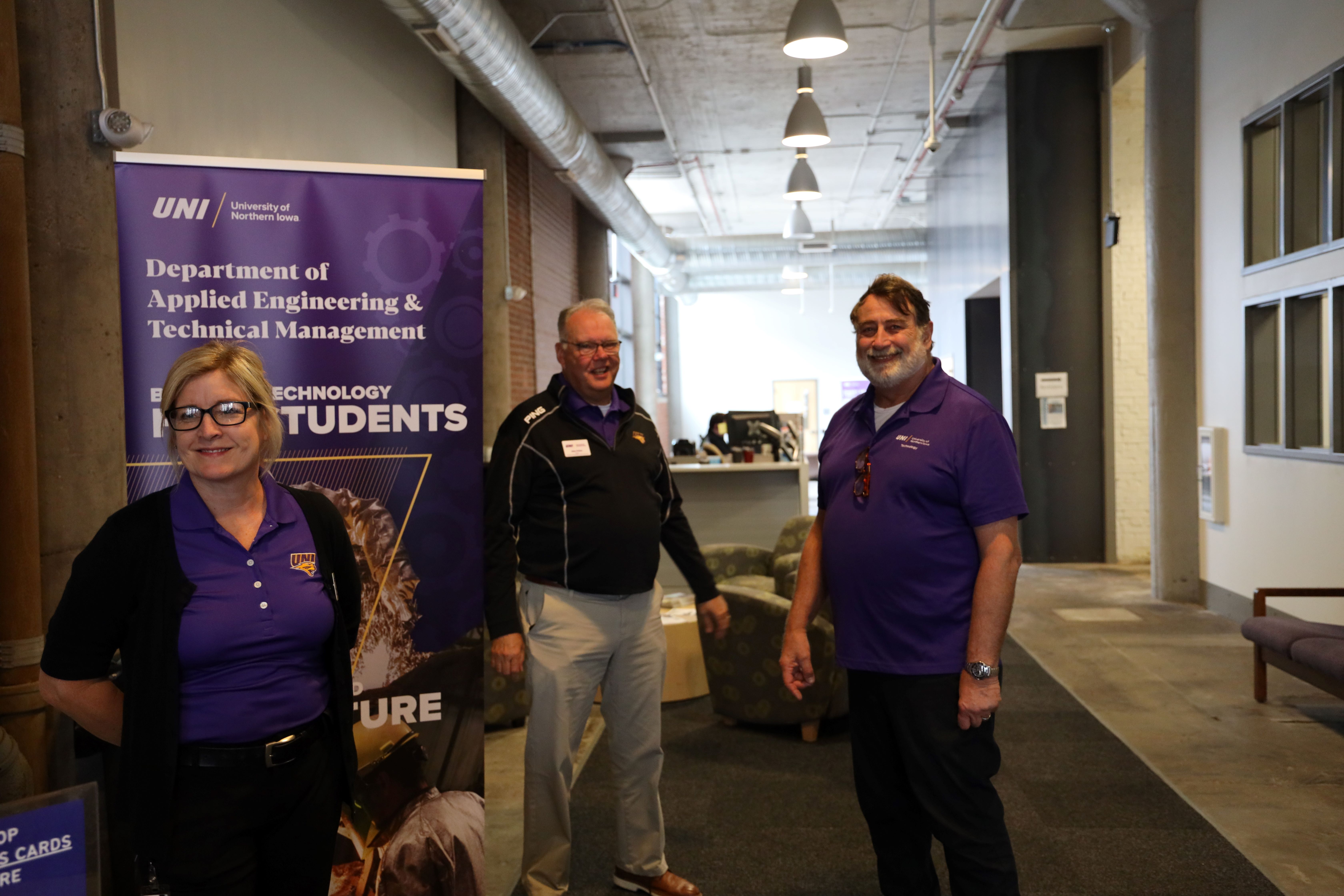 Three UNI employees smiling for a photo. 